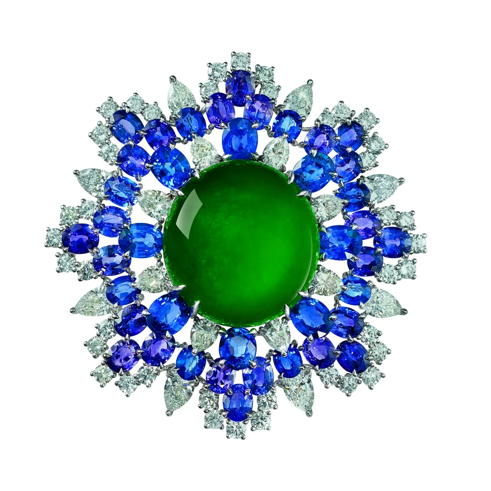 DeGem Blooming Jade Pendant and Brooch featuring a vivid Imperial green jadeite cabochon surrounded by oval blue sapphires and pear-shaped diamonds in white gold — an exceptional example of high-grade green jadeite colour